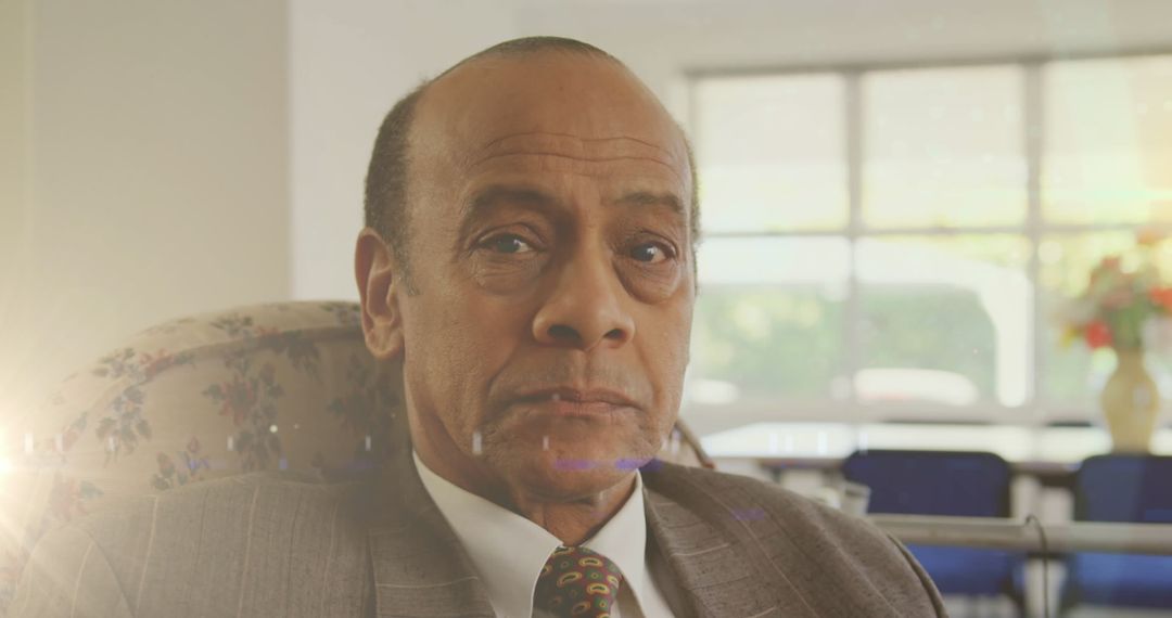 Serious Senior Man Relaxing in Chair with Sunbeam Glare