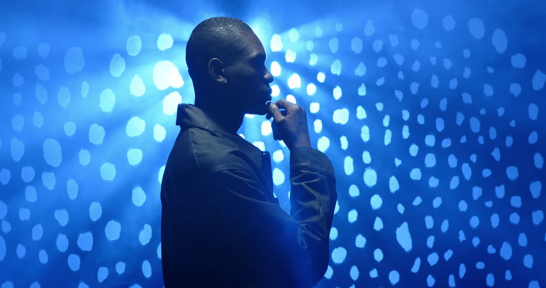 Thoughtful Man in Silhouette with Blue Bokeh Lights