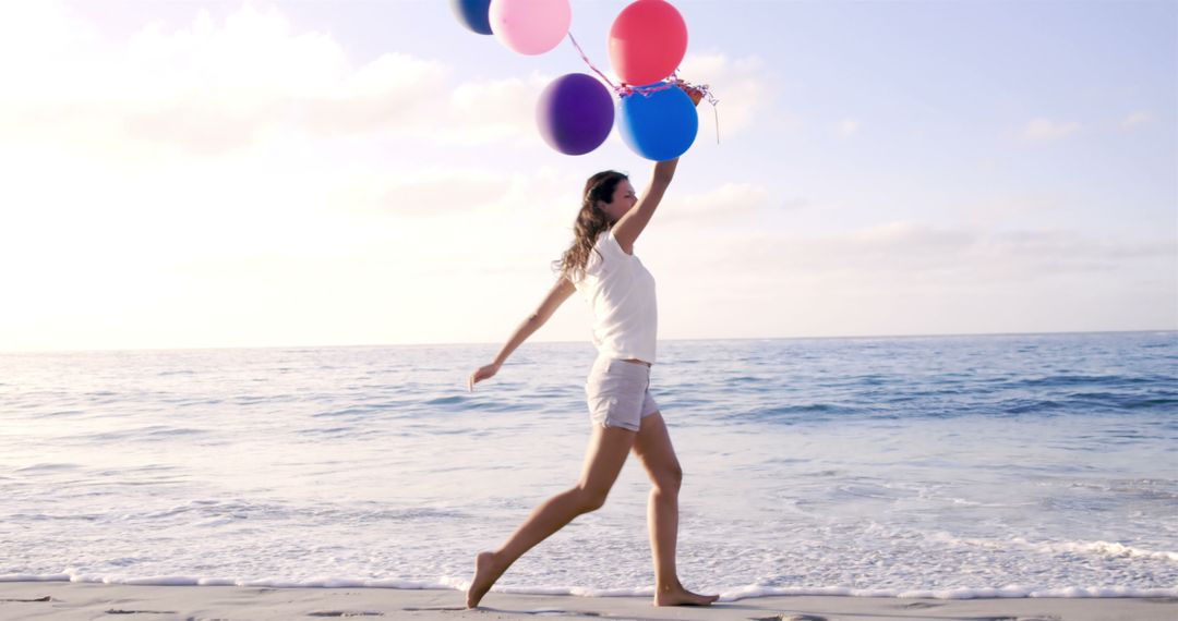 Young Woman Holding Colorful Balloons Walking on Beach - Free Images, Stock Photos and Pictures on Pikwizard.com