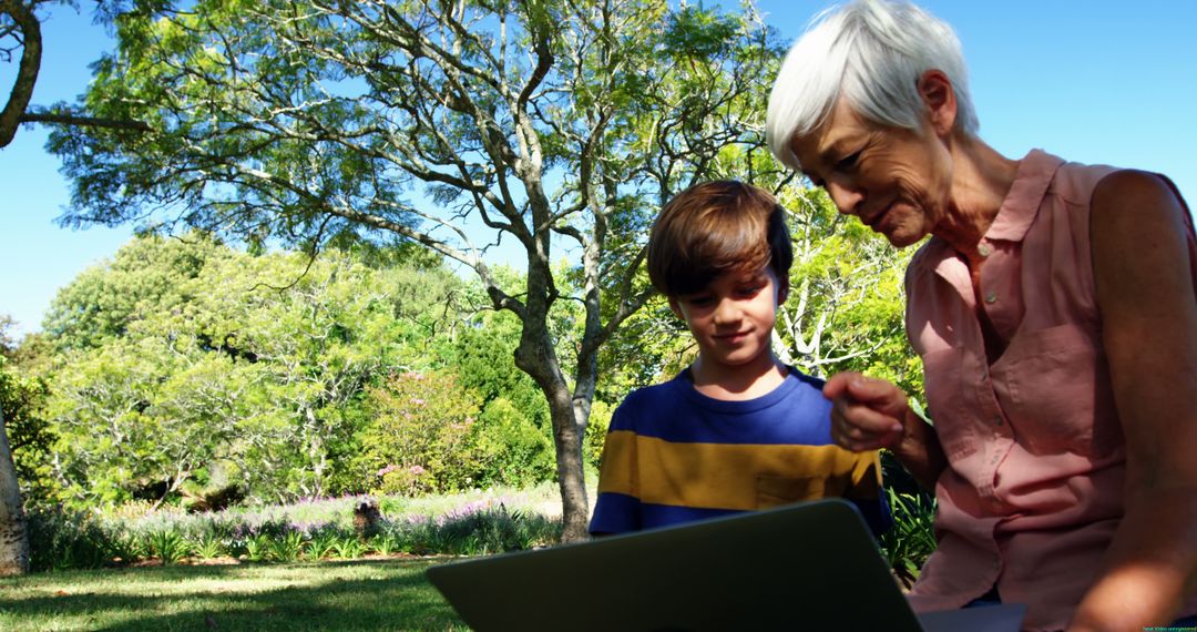 Grandmother and Grandson Using Laptop Outdoors in Park - Free Images, Stock Photos and Pictures on Pikwizard.com