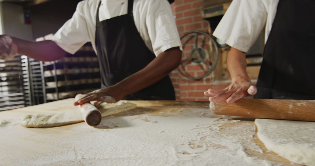 Bakers preparing dough with rolling pins in bakery kitchen - Free Images, Stock Photos and Pictures on Pikwizard.com