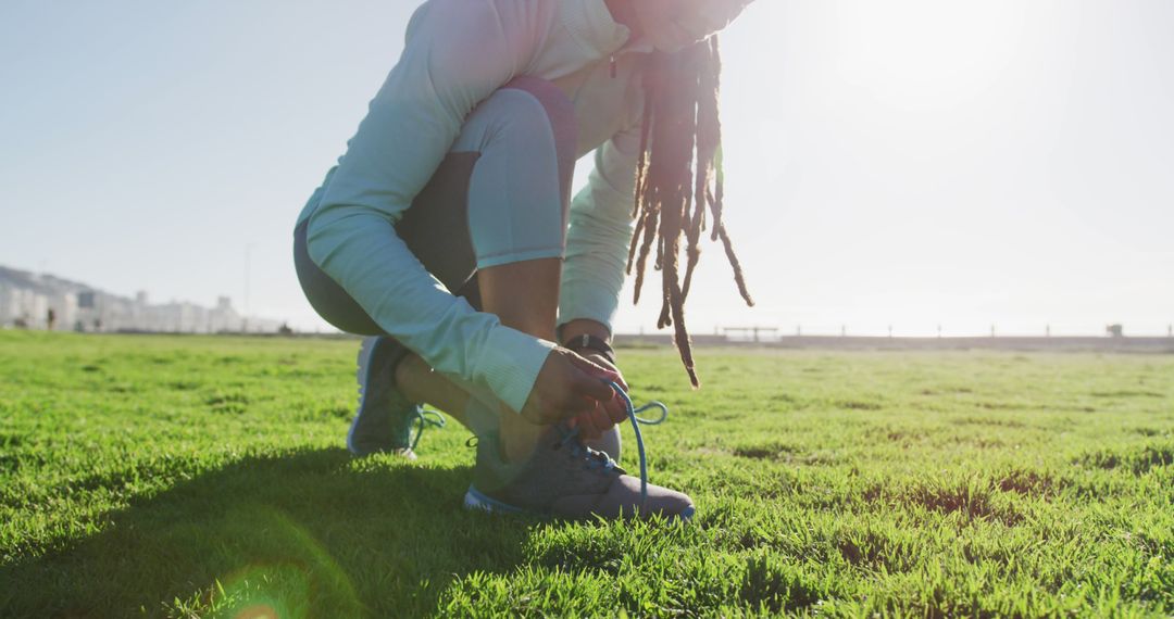 Woman Tying Running Shoes on Grass in Bright Sunlight - Free Images, Stock Photos and Pictures on Pikwizard.com