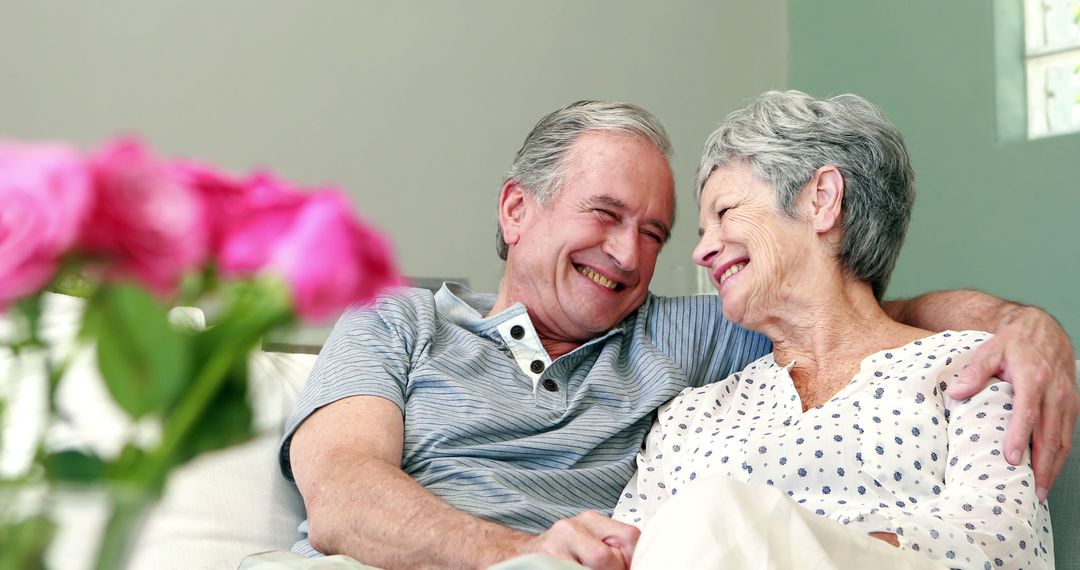 Senior Couple Embracing Joyfully on Living Room Sofa - Free Images, Stock Photos and Pictures on Pikwizard.com