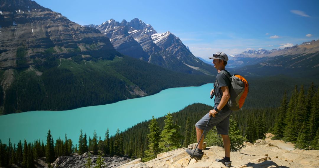 Man Hiking with Backpack Overlooking Scenic Mountain Lake - Free Images, Stock Photos and Pictures on Pikwizard.com