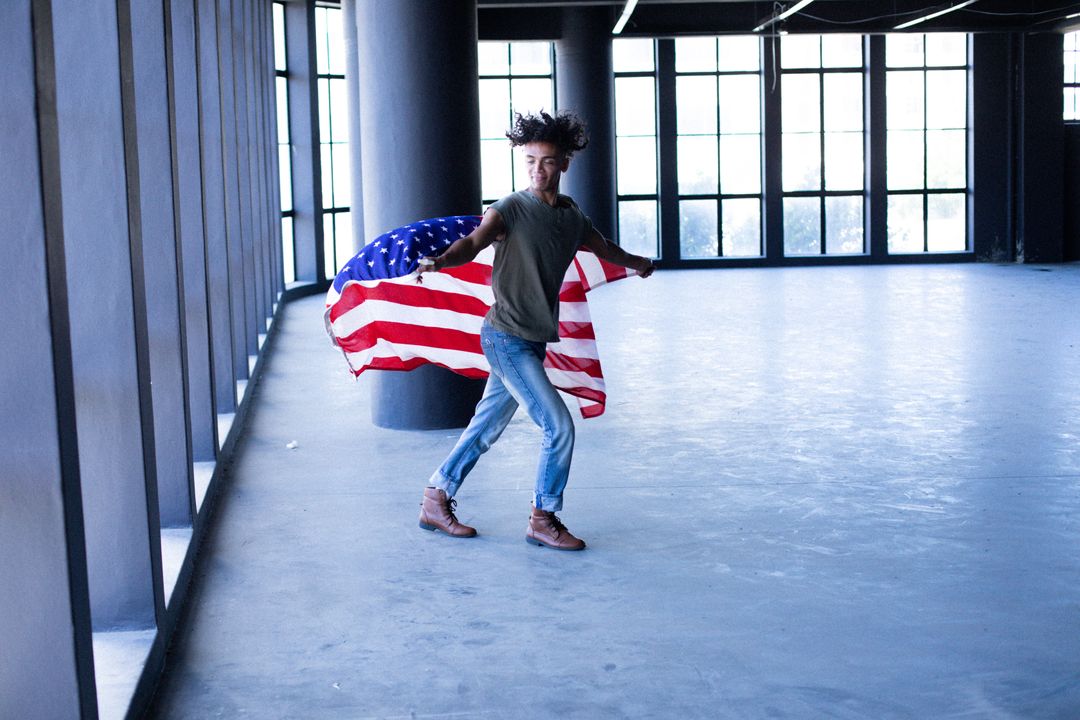 Transgender Man Holding American Flag in Empty Parking Garage - Free Images, Stock Photos and Pictures on Pikwizard.com