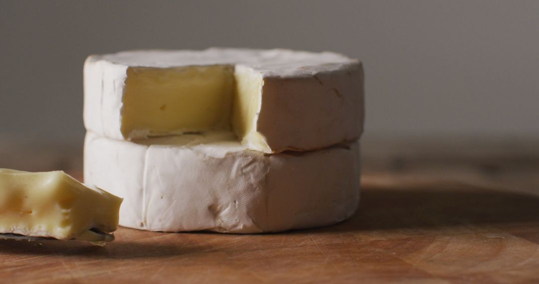 Close-Up of Two Wheels of Brie Cheese on Wooden Surface - Free Images, Stock Photos and Pictures on Pikwizard.com