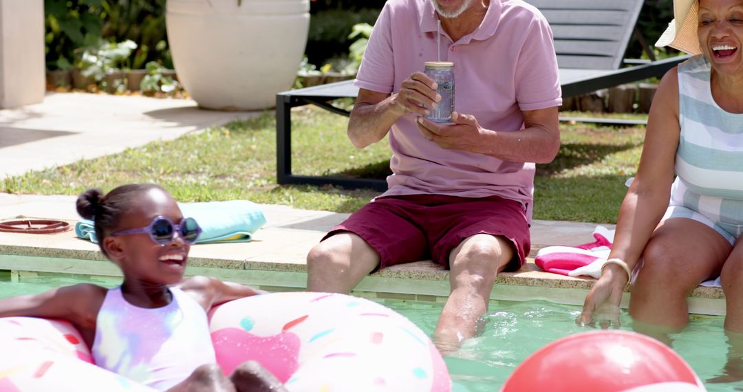 Family Enjoying Poolside Fun with Drinks and Inflatables