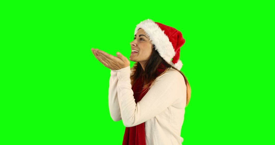 Woman Blowing Kiss Wearing Santa Hat Isolated on Green Background - Free Images, Stock Photos and Pictures on Pikwizard.com