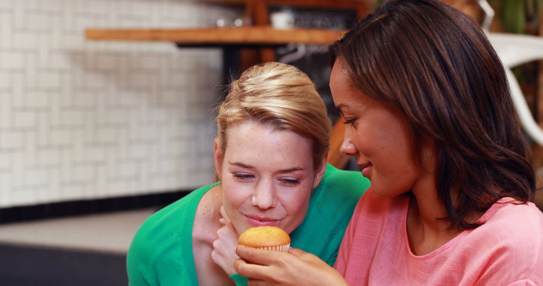 Two Women Enjoying Freshly Baked Muffin Together in Modern Cafe - Free Images, Stock Photos and Pictures on Pikwizard.com