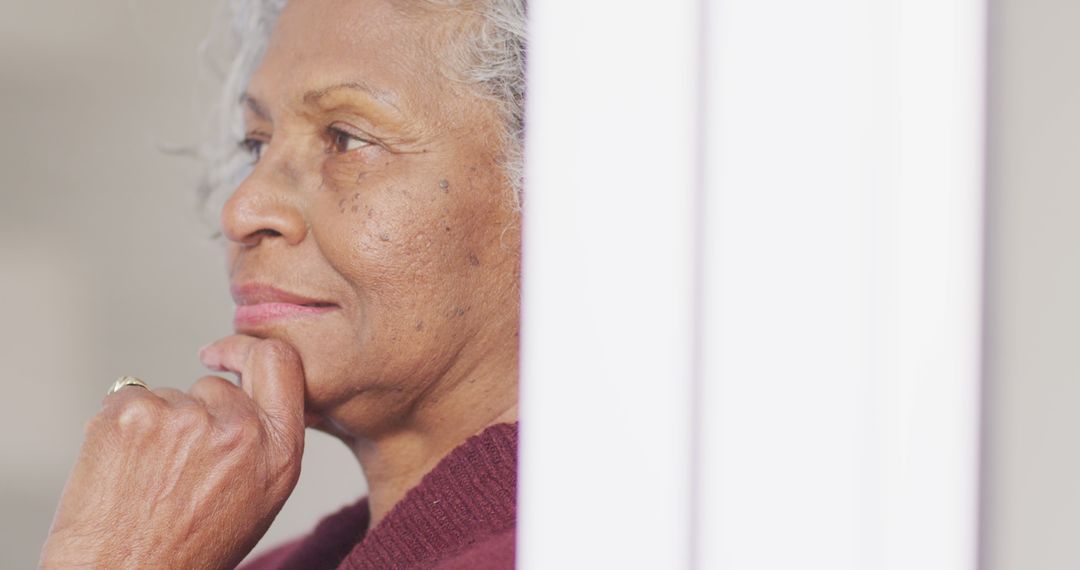 Senior Woman Gazing Out Window in Reflective Pose