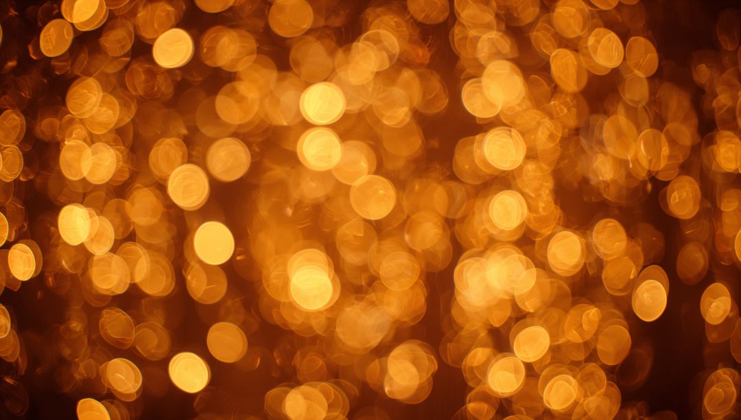 Glowing gold bokeh lights filling dark backdrop with warm festive sparkle and amber orbs