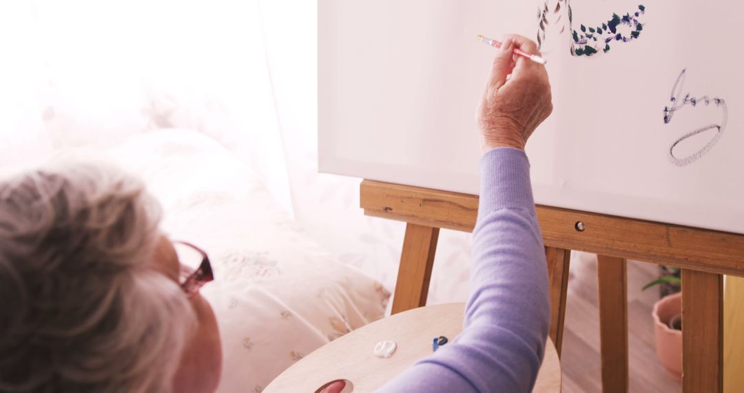 Senior Woman Painting On Canvas In Bright Studio - Free Images, Stock Photos and Pictures on Pikwizard.com