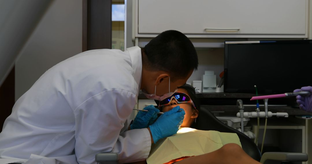 Dentist Treating Patient with Dental Equipment in Clinic - Free Images, Stock Photos and Pictures on Pikwizard.com