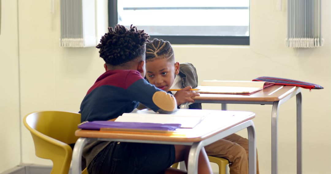 Schoolboys Collaborating over Work in Well Lit Classroom Setting