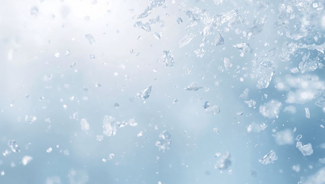 Glittering Ice Crystals Floating in Soft Blue Bokeh Background for Winter Design