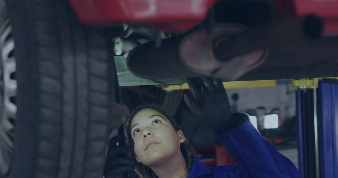 Mechanic Inspecting Car Exhaust in Garage Workshop