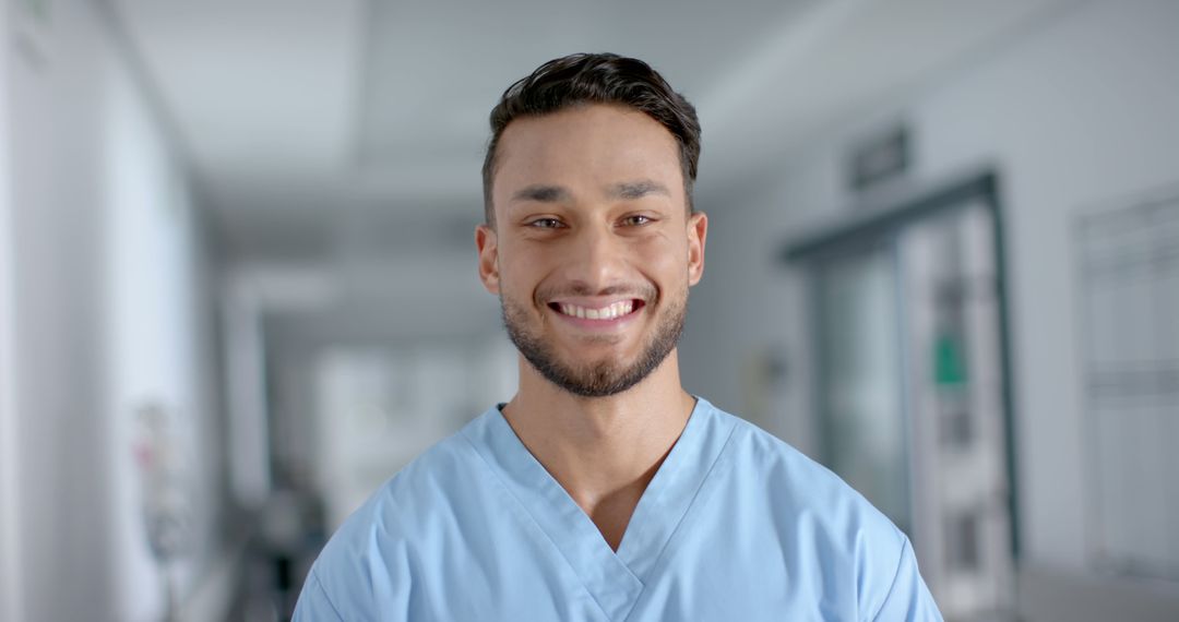 Smiling Male Nurse in Scrubs at Hospital Corridor - Free Images, Stock Photos and Pictures on Pikwizard.com