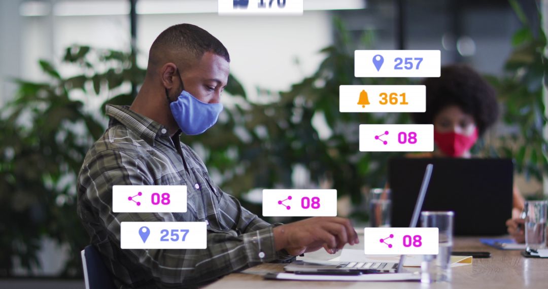 Man in Mask Working on Laptop with Social Media Icons