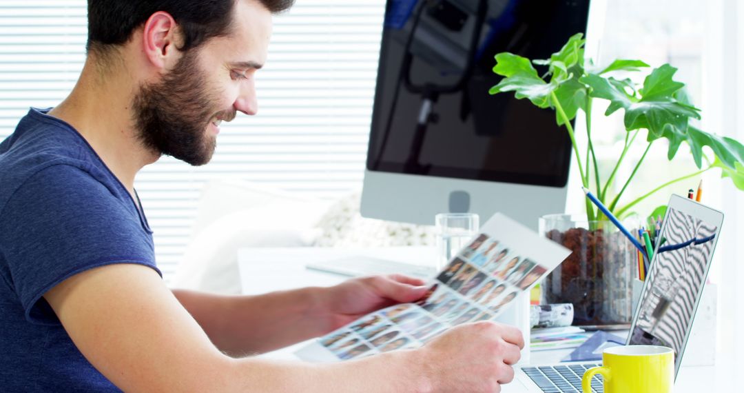 Designer Working at Desk with Printed Photos - Free Images, Stock Photos and Pictures on Pikwizard.com