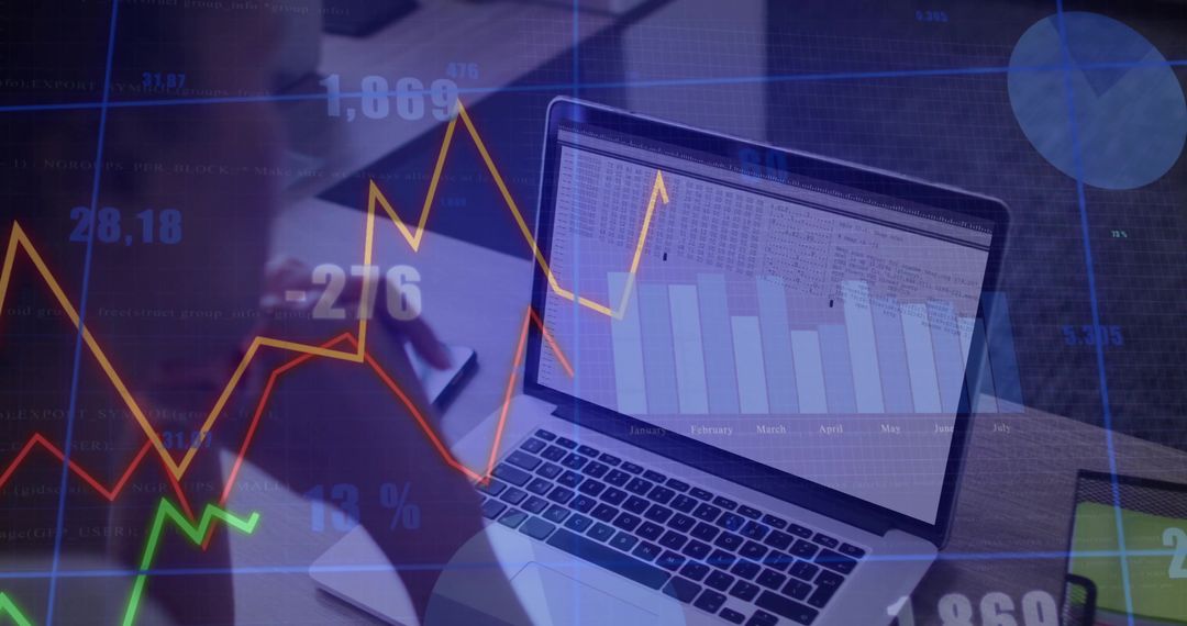 Writing business notes on laptop with financial charts and analytics overlays