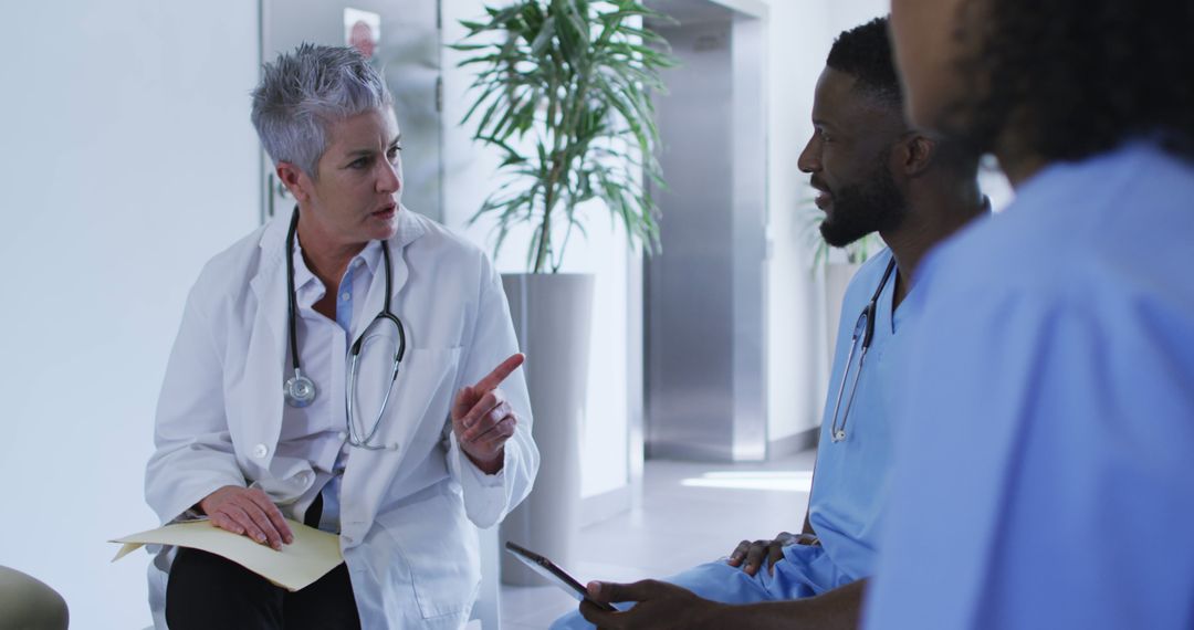 Senior Doctor Discussing Patient Case with Medical Team in Hospital - Free Images, Stock Photos and Pictures on Pikwizard.com