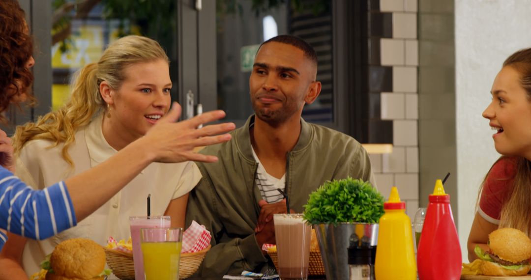 Diverse Friends Enjoying Conversation at Diner with Food and Drinks