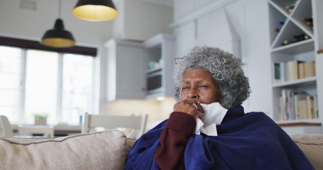 Elderly Woman Wrapped in Blanket at Home Coughing with Tissues - Free Images, Stock Photos and Pictures on Pikwizard.com