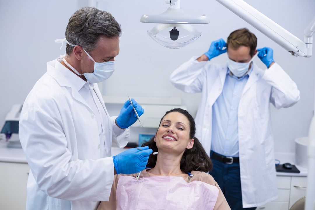 Dentist examining a female patient with tools - Free Images, Stock Photos and Pictures on Pikwizard.com