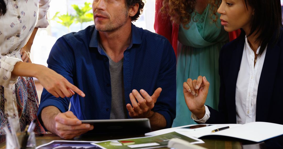 Diverse Team Collaborating in Office Meeting on Tablet