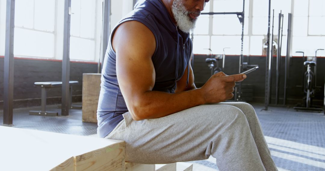 Senior Man Checking Smartphone During Gym Workout - Free Images, Stock Photos and Pictures on Pikwizard.com