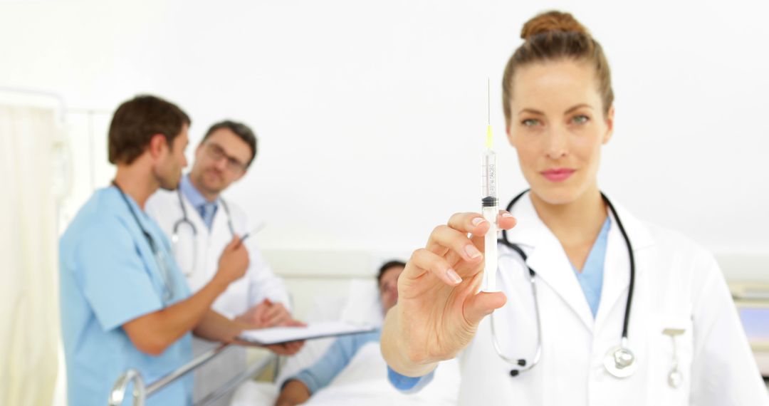 Female Doctor Holding Syringe with Colleagues in Background - Free Images, Stock Photos and Pictures on Pikwizard.com