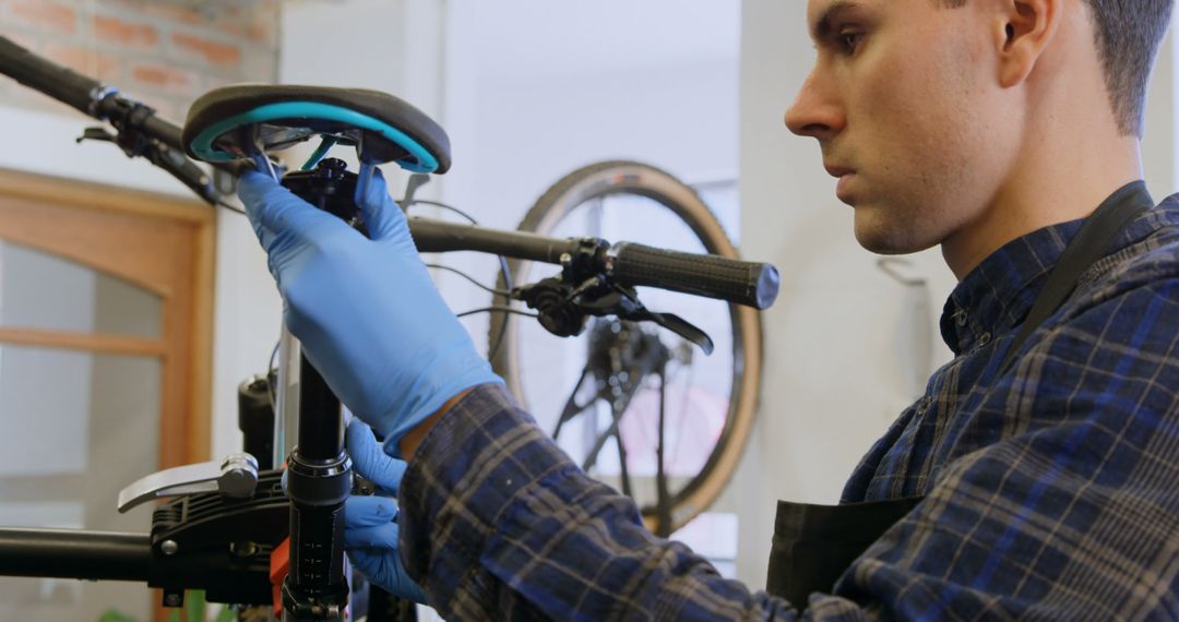 Bicycle Mechanic Adjusting Saddle in Workshop - Free Images, Stock Photos and Pictures on Pikwizard.com