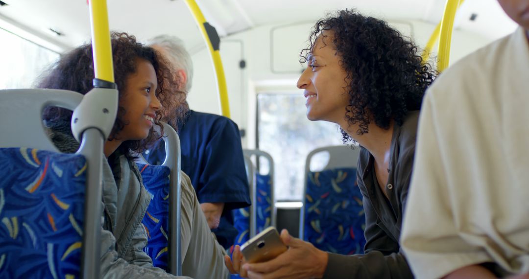 Mother and Daughter Smiling and Interacting on a Bus Journey Together - Free Images, Stock Photos and Pictures on Pikwizard.com