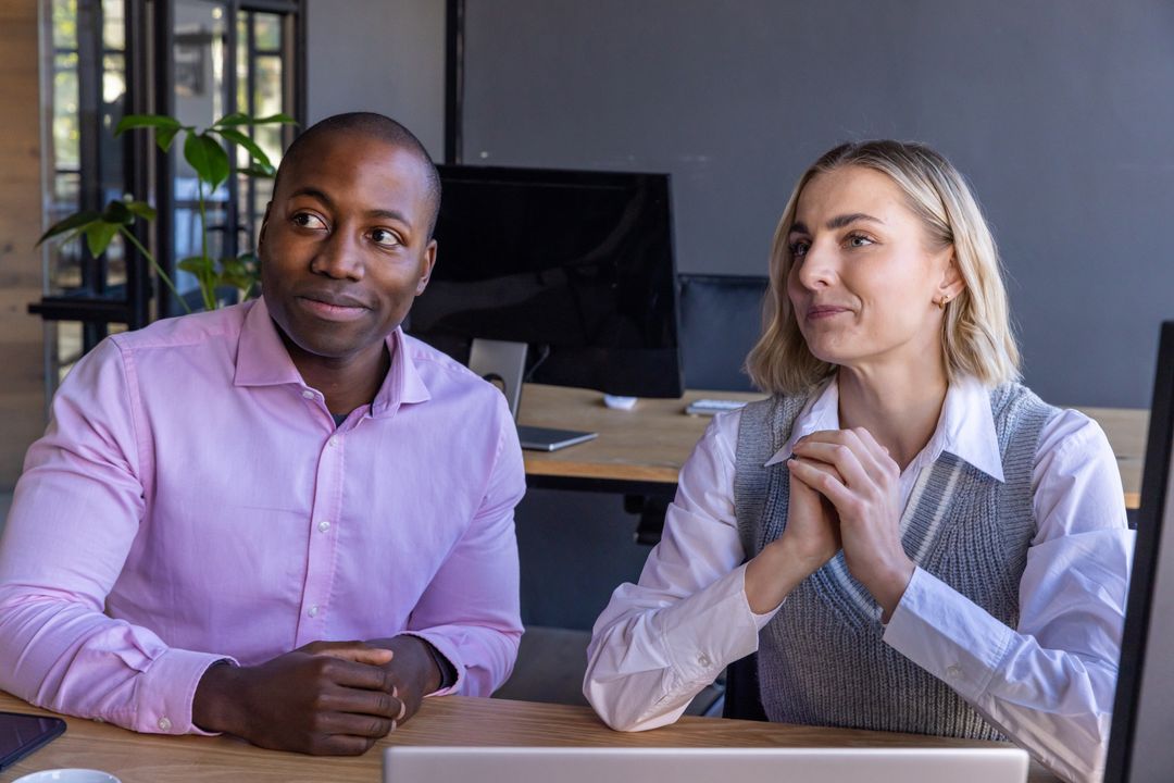Diverse Coworkers Engaged in Professional Discussion at Office Desk