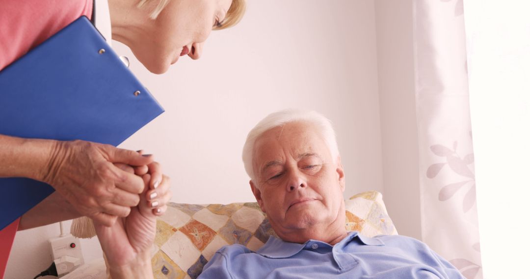 Nurse Supporting Elderly Patient Lying in Bed - Free Images, Stock Photos and Pictures on Pikwizard.com