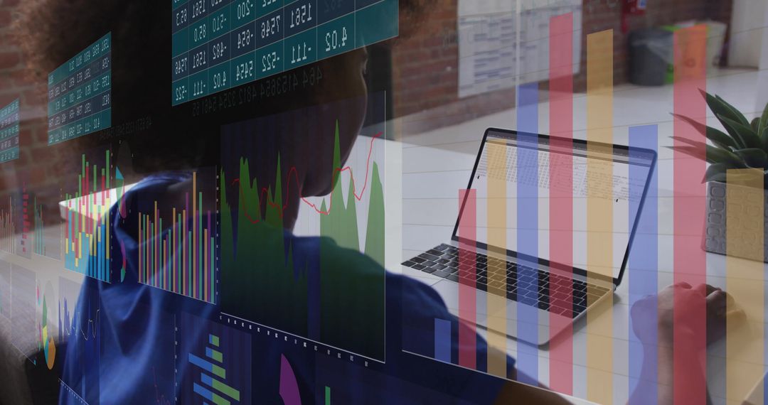 Business Analyst Reviewing Data Projections with Laptop and Charts