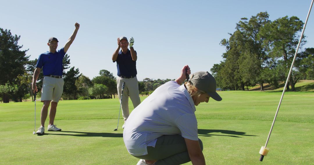 Senior Golfers Celebrating Successful Putt on Sunny Course