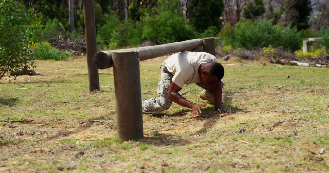 Man in Military Training Crawling in Outdoor Obstacle Course