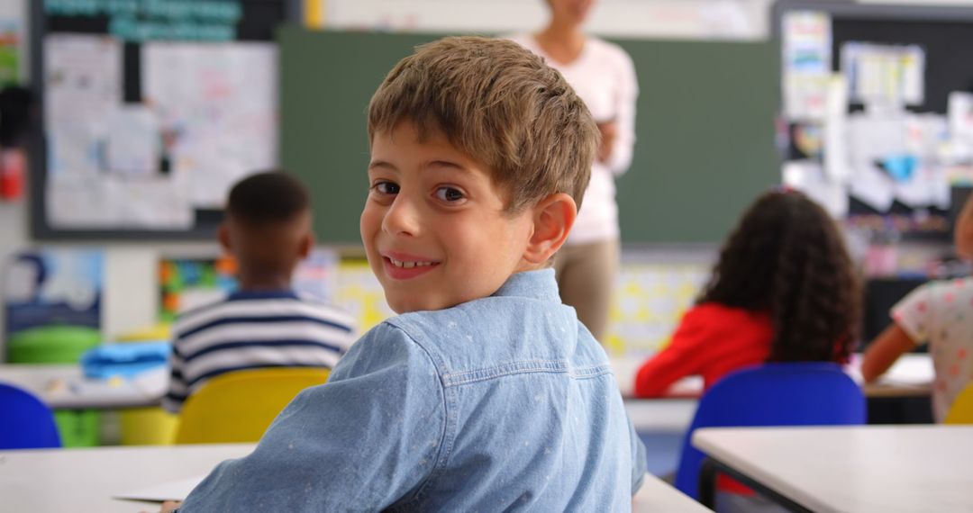 Smiling Schoolboy in Classroom with Teacher in Background