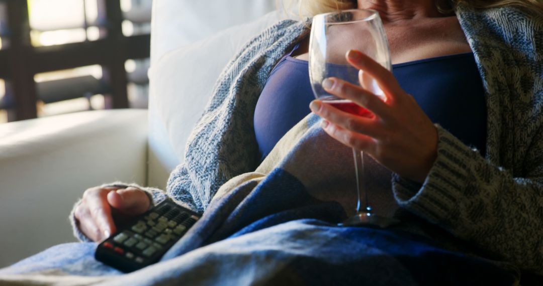 Woman Relaxing on Sofa with Wine and TV Remote - Free Images, Stock Photos and Pictures on Pikwizard.com