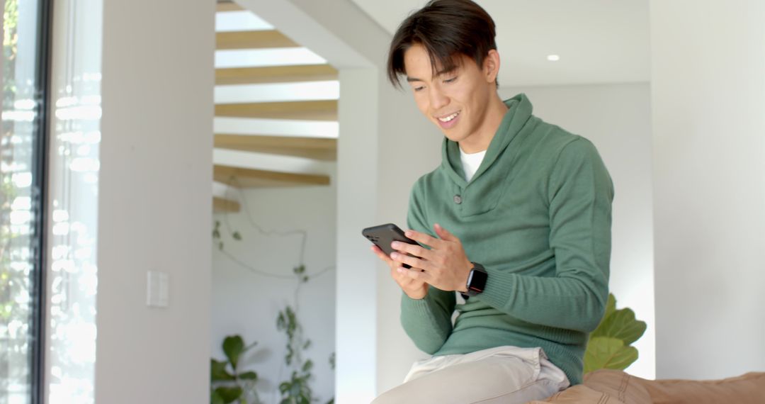 Asian Man Enjoying Technology Seated at Home