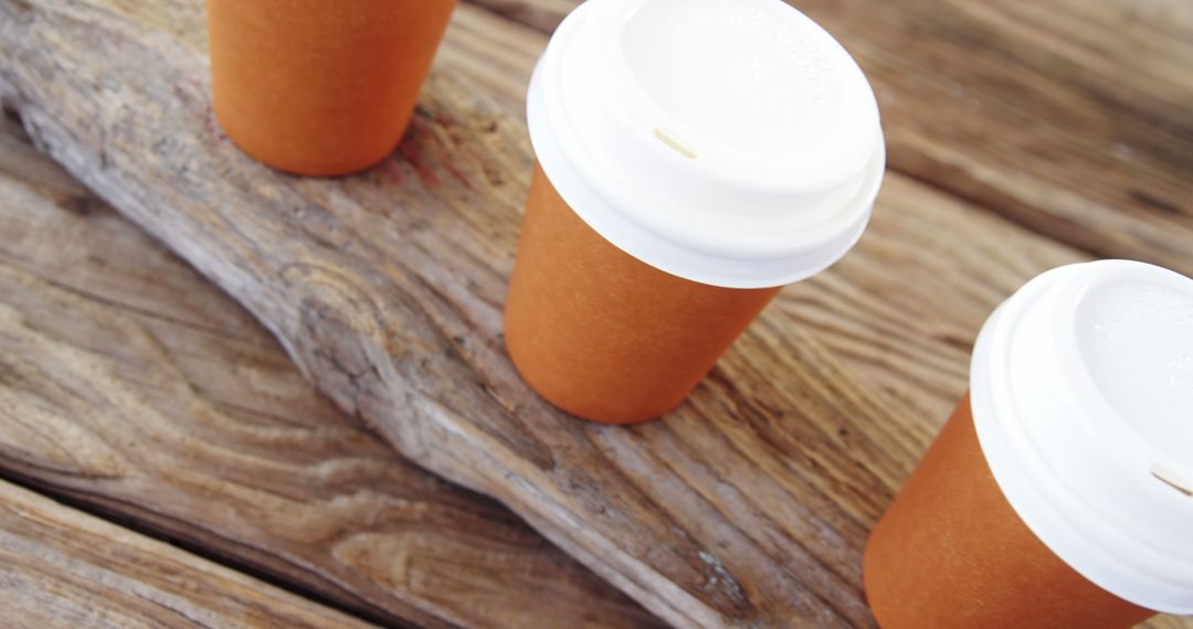 Close-Up of Three Takeaway Coffee Cups on Wooden Table - Free Images, Stock Photos and Pictures on Pikwizard.com