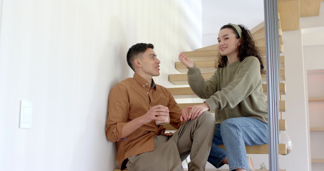 Couple Relaxing on Modern Floating Staircase with Coffee Mug