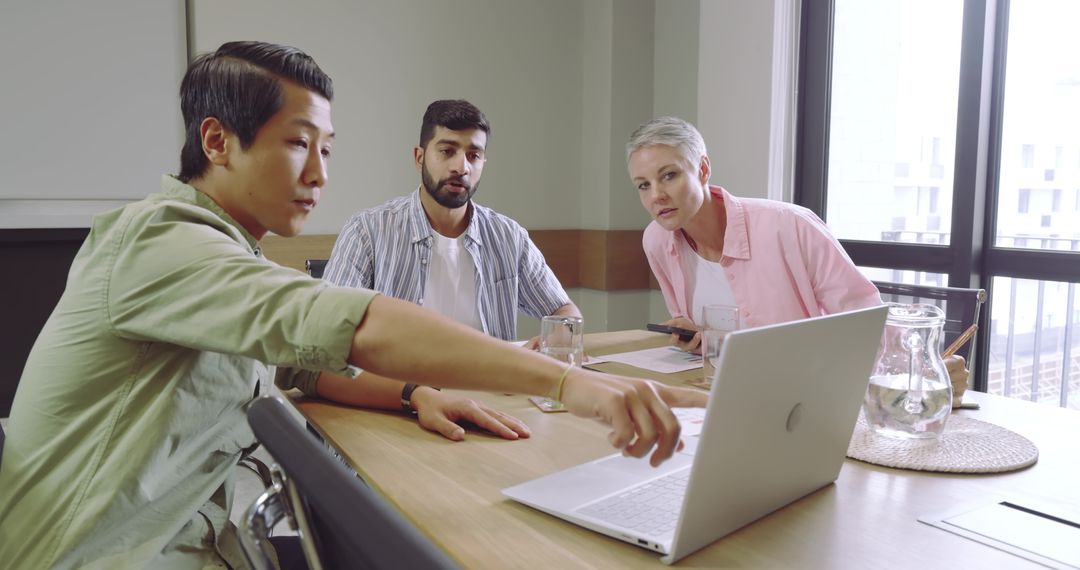 Diverse Team Collaboration Around Laptop at Modern Office