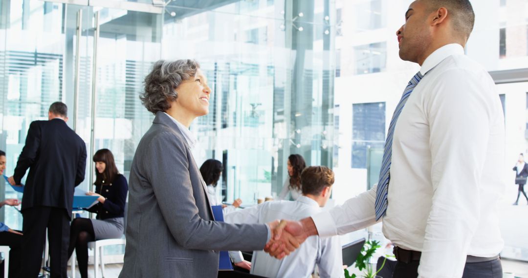 Diverse Business Colleagues Shaking Hands in Modern Office Setting
