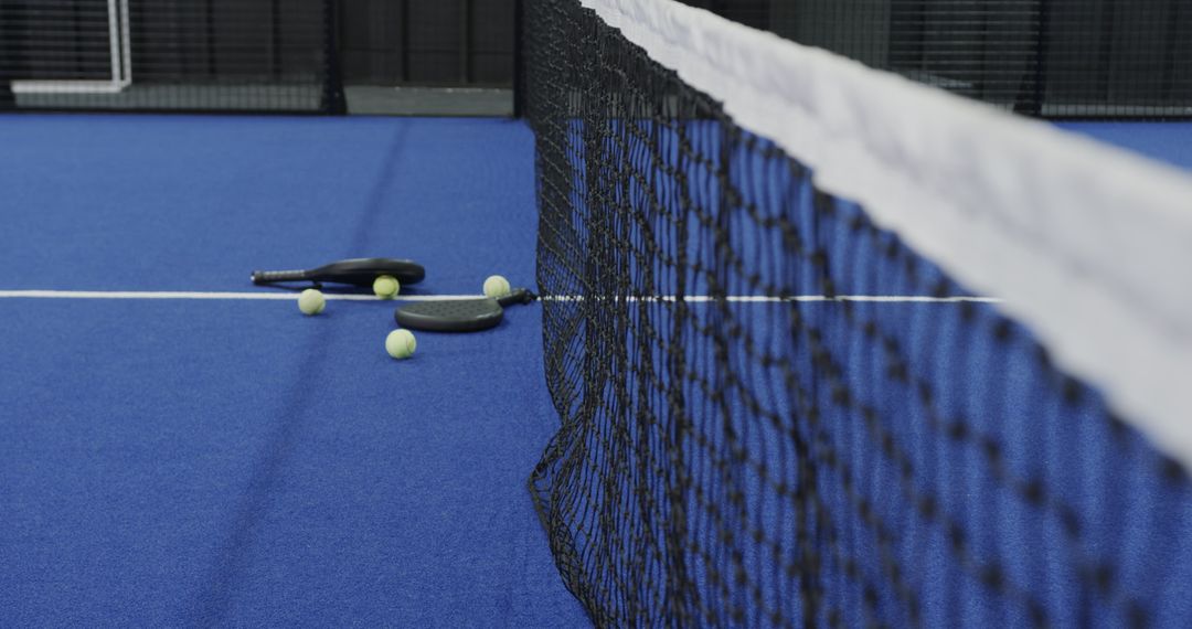 Scenic Padel Court with Rackets and Balls on Blue Surface
