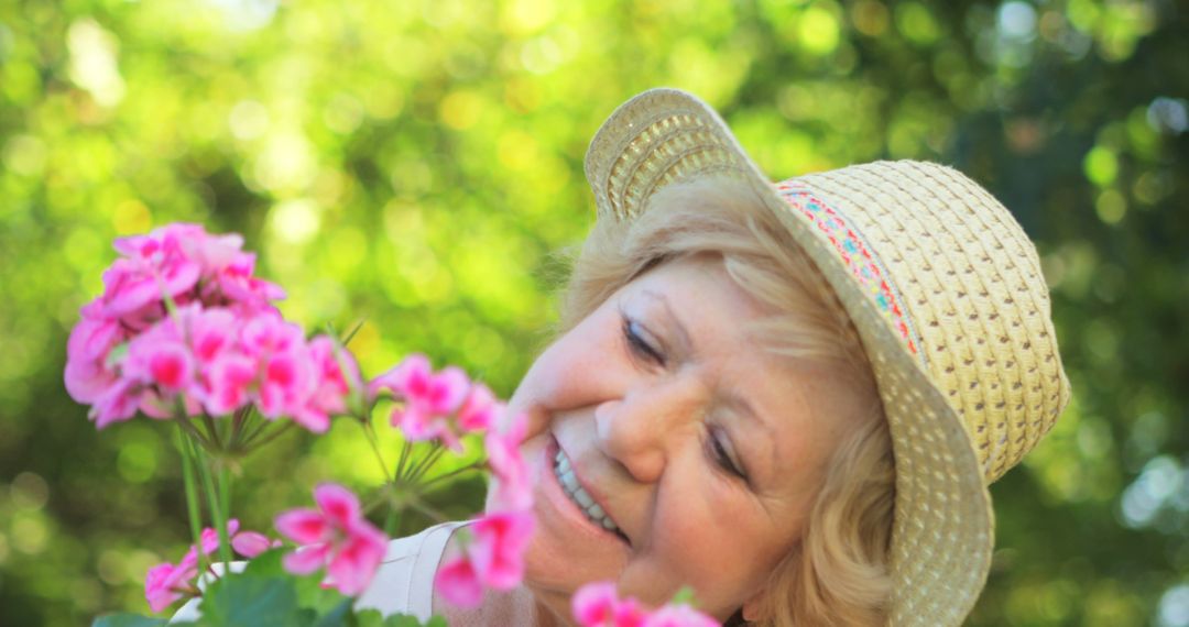 Happy Elderly Woman Enjoying Blossoming Pink Flowers in a Garden - Free Images, Stock Photos and Pictures on Pikwizard.com