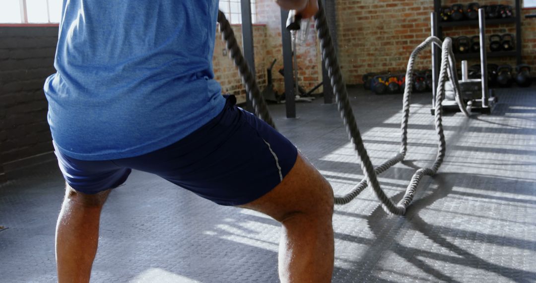 Close-Up of Man Exercising with Battle Ropes in Industrial Gym - Free Images, Stock Photos and Pictures on Pikwizard.com