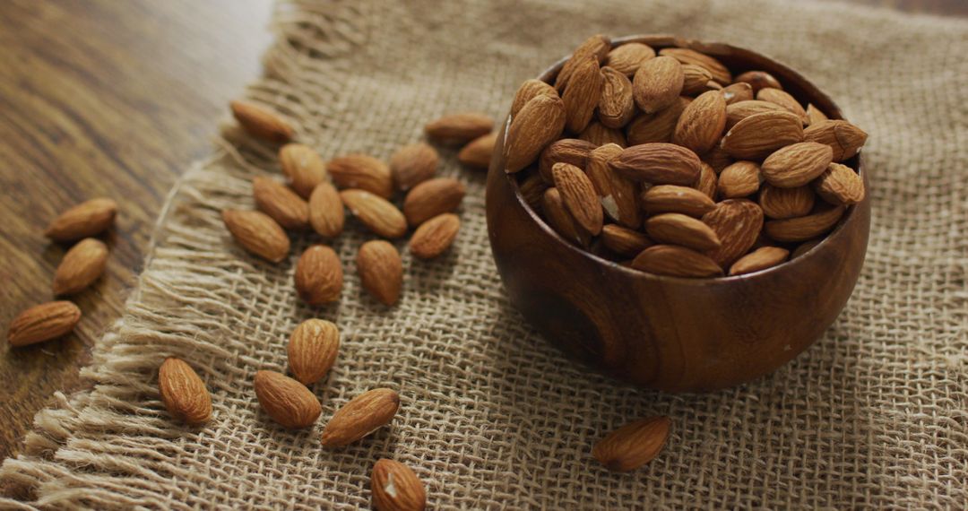Almonds in Wooden Bowl on Burlap for Healthy Eating Concept