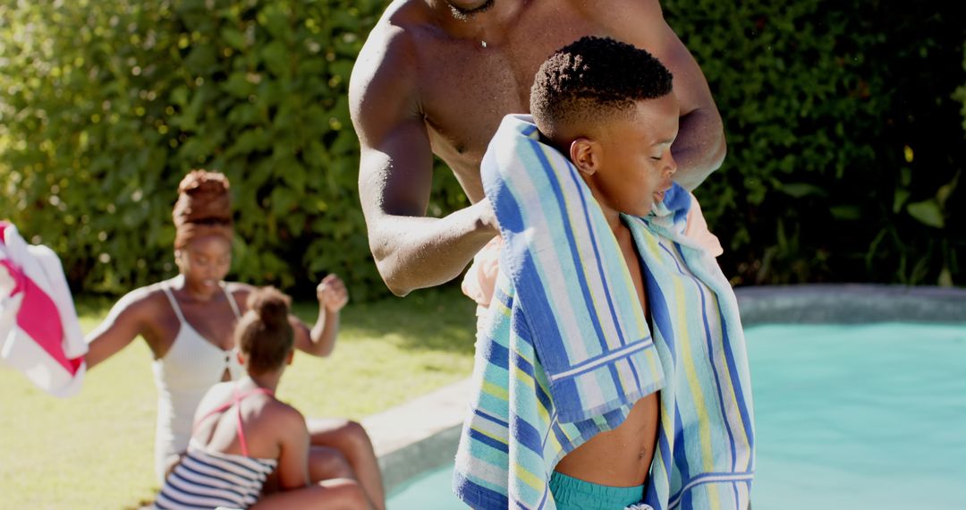 Father Helping Son Dry with Towel After Swimming at Poolside